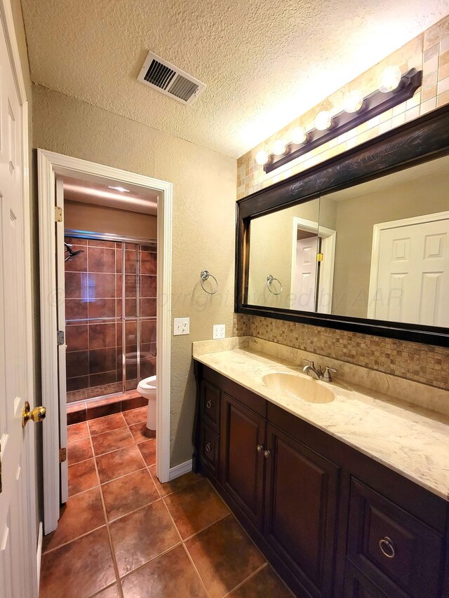 full bath featuring vanity, visible vents, tile patterned flooring, a textured ceiling, and toilet