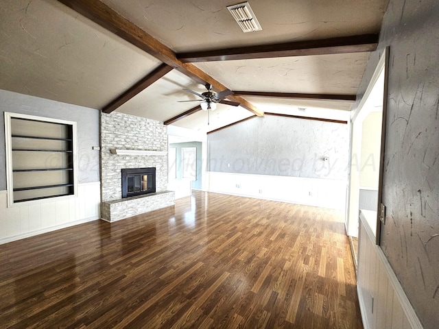 unfurnished living room with visible vents, built in shelves, lofted ceiling with beams, a fireplace, and wood finished floors