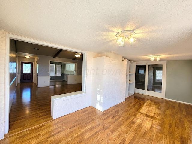 unfurnished room featuring visible vents, a textured ceiling, and wood finished floors