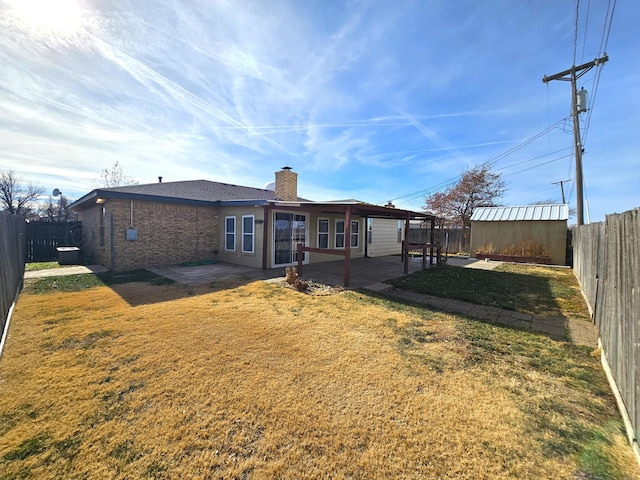 back of property with a patio, a yard, and a fenced backyard