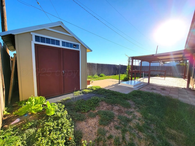 view of yard featuring a patio, a shed, a fenced backyard, a pergola, and an outdoor structure