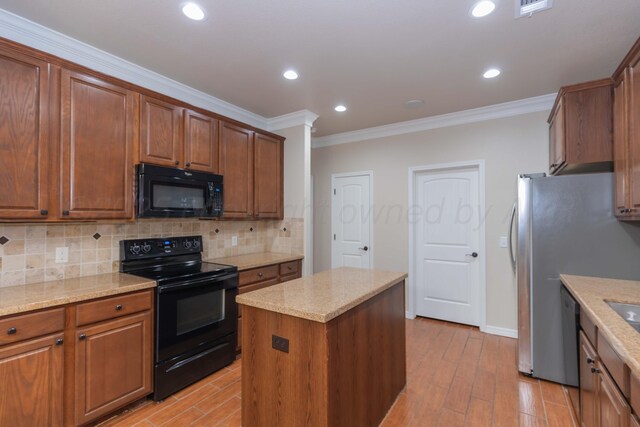 7111 Mosley St, Amarillo, TX 79119 - kitchen featuring ornamental molding, a kitchen island, tasteful backsplash, light wood-style flooring, and black appliances