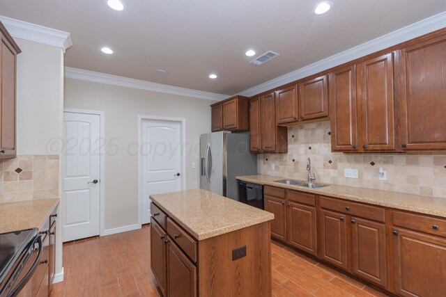 7111 Mosley St, Amarillo, TX 79119 - kitchen featuring visible vents, crown molding, a sink, light wood finished floors, and black appliances