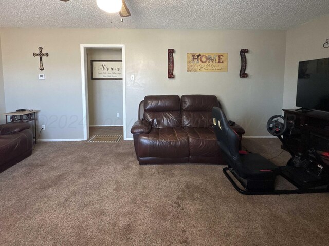 carpeted living room with ceiling fan and a textured ceiling