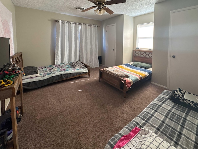 carpeted bedroom featuring ceiling fan and a textured ceiling