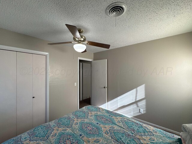 bedroom featuring ceiling fan, a textured ceiling, and a closet