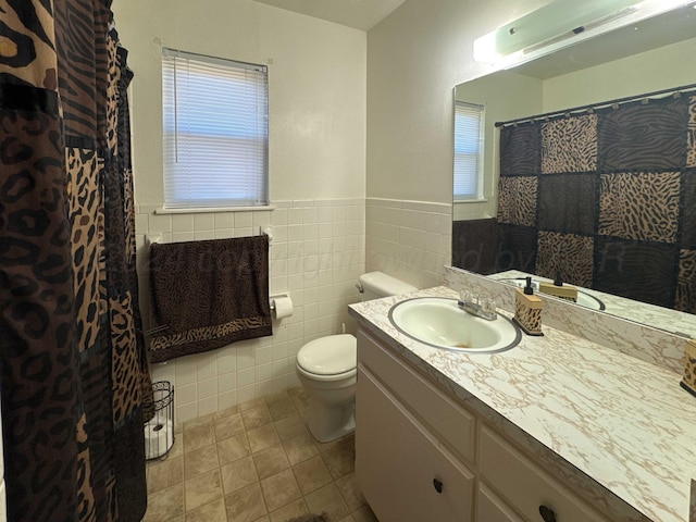 bathroom featuring plenty of natural light, tile patterned flooring, vanity, and tile walls