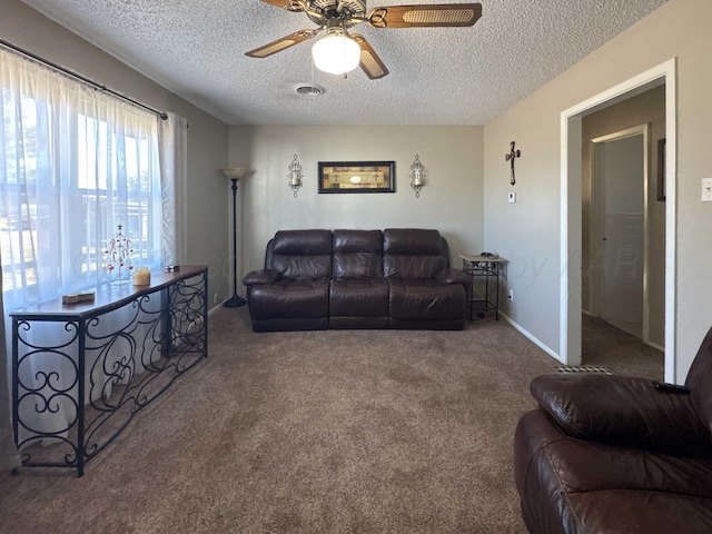 carpeted living room featuring a textured ceiling and ceiling fan