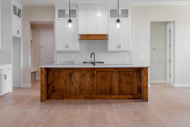 5805 Sheridan St, Amarillo, TX 79119 - kitchen featuring a sink, decorative backsplash, light countertops, white cabinets, and a center island with sink