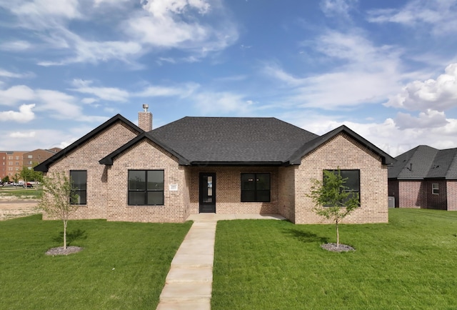 5805 Sheridan St, Amarillo, TX 79119 - view of front facade with brick siding, a front yard, a chimney, and a shingled roof