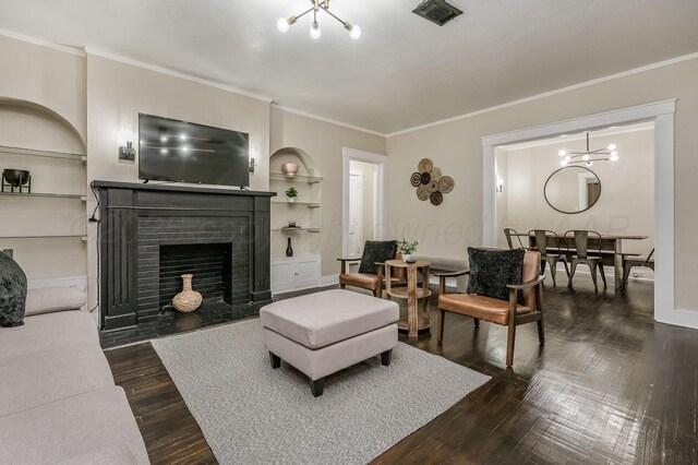 505 S Belleview St, Amarillo, TX 79106 - living area with a chandelier, built in shelves, ornamental molding, dark wood finished floors, and a brick fireplace