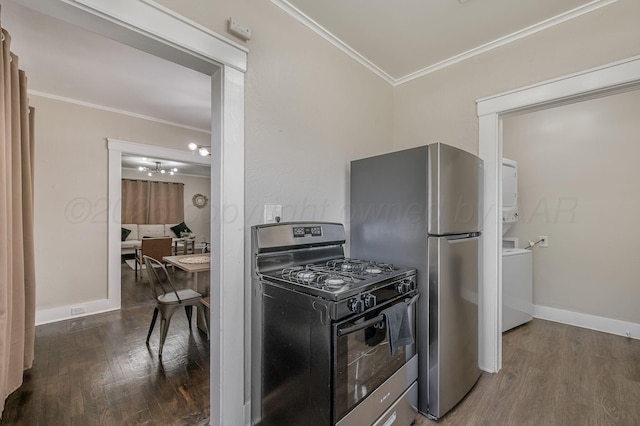 505 S Belleview St, Amarillo, TX 79106 - kitchen featuring black range with gas cooktop, estacked washer and dryer, crown molding, wood finished floors, and baseboards
