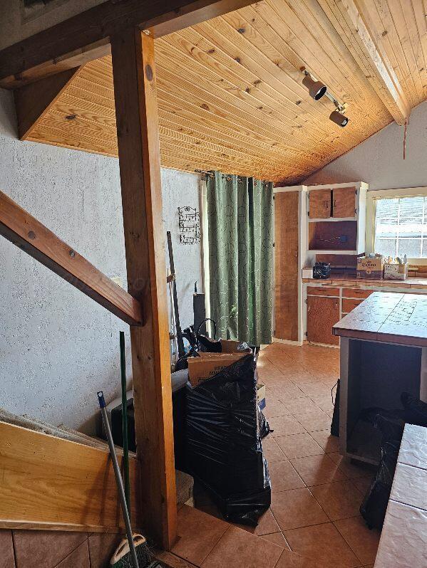 interior space featuring lofted ceiling with beams and wooden ceiling