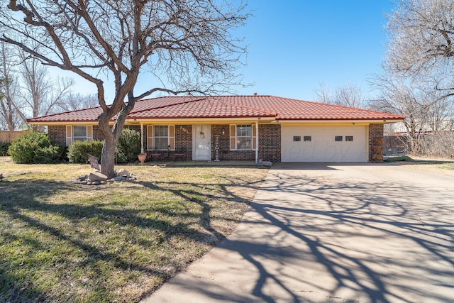 ranch-style home with brick siding, a front lawn, an attached garage, and a tile roof