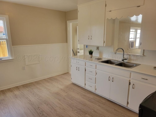 1020 N Nelson St, Amarillo, TX 79107 - kitchen featuring a sink, white cabinetry, light countertops, light wood-type flooring, and black / electric stove