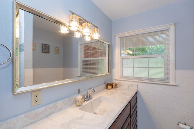 bathroom with vanity, wainscoting, and a chandelier