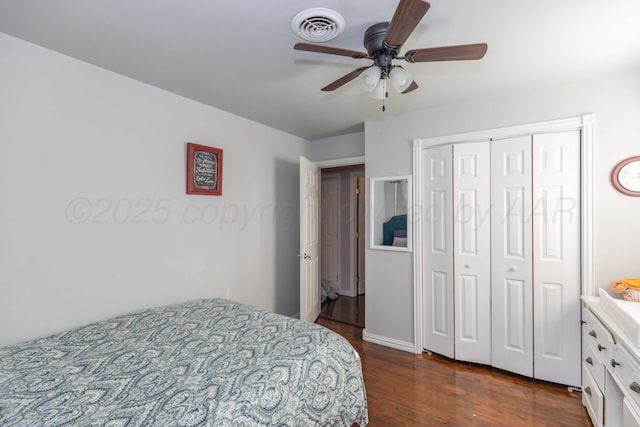 bedroom with dark wood-style flooring, a ceiling fan, and a closet