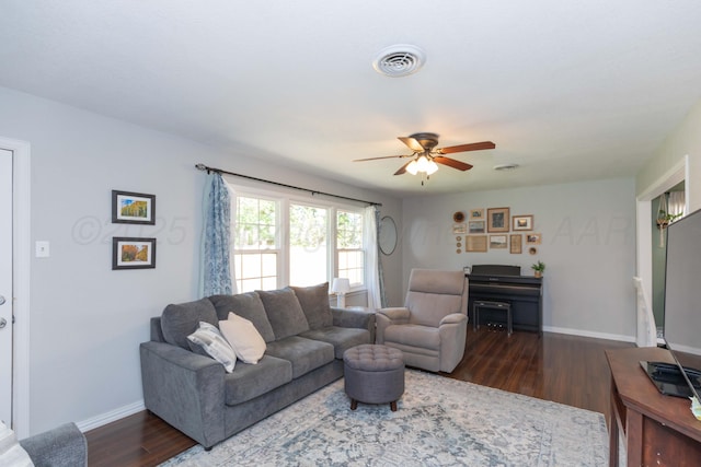 living area featuring ceiling fan, dark wood-style flooring, and baseboards