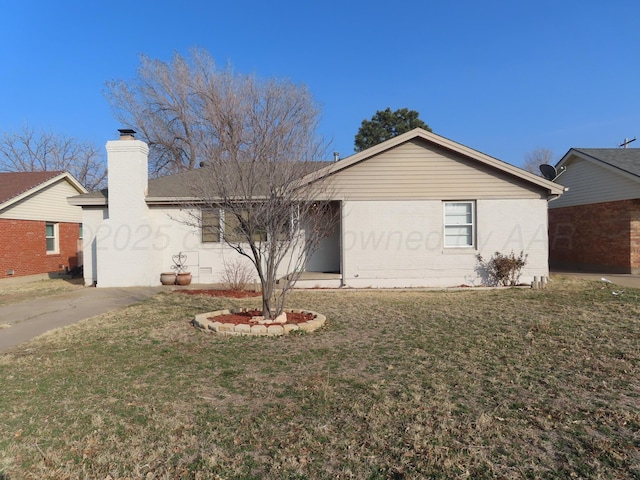 ranch-style house with brick siding, a chimney, and a front lawn