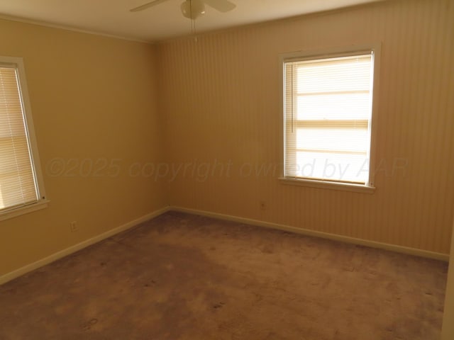carpeted spare room with ceiling fan and baseboards