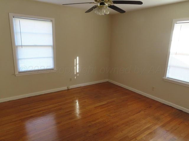 empty room with baseboards, ceiling fan, and wood finished floors