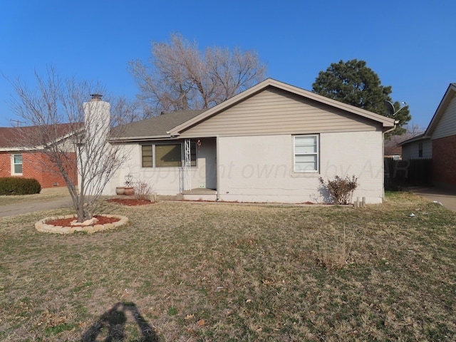 ranch-style house with a chimney and a front yard