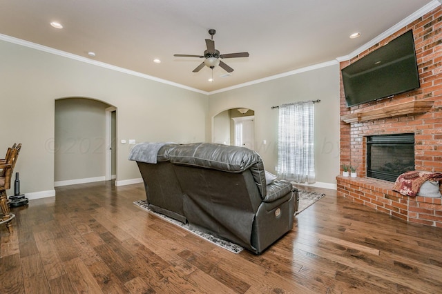 living room featuring ornamental molding, a fireplace, and dark hardwood / wood-style flooring