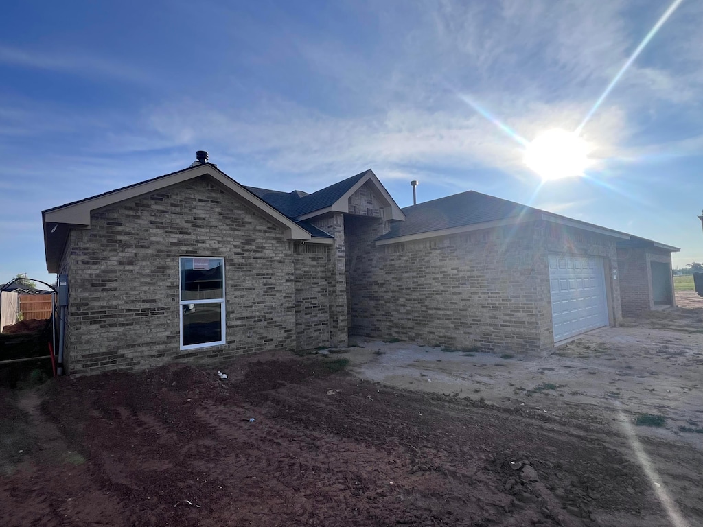 848 Torres Dr, Hereford, TX 79045 - view of side of property with an attached garage, driveway, and brick siding