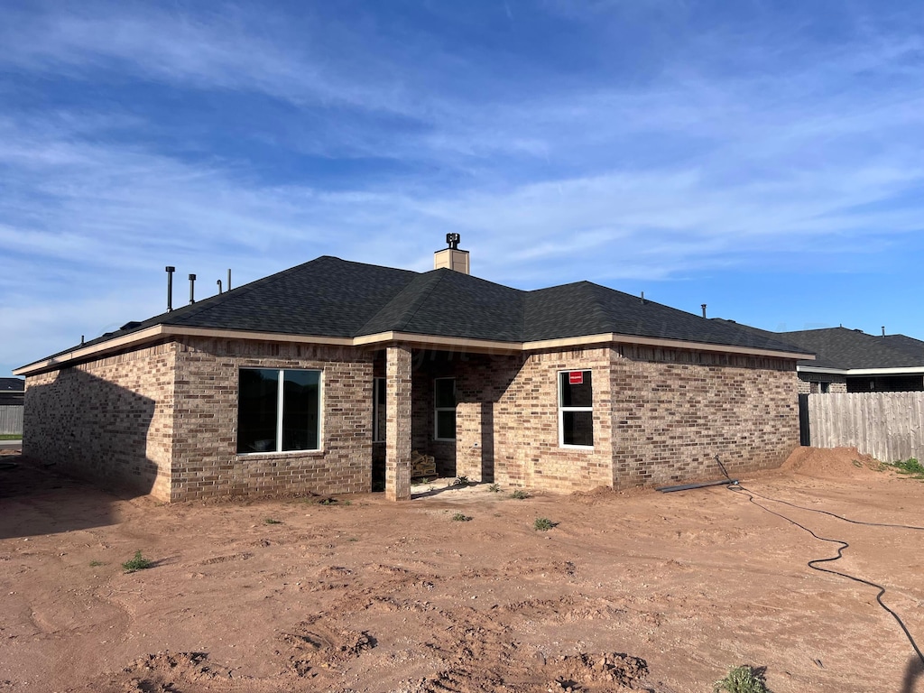 848 Torres Dr, Hereford, TX 79045 - rear view of house featuring a chimney, brick siding, and roof with shingles