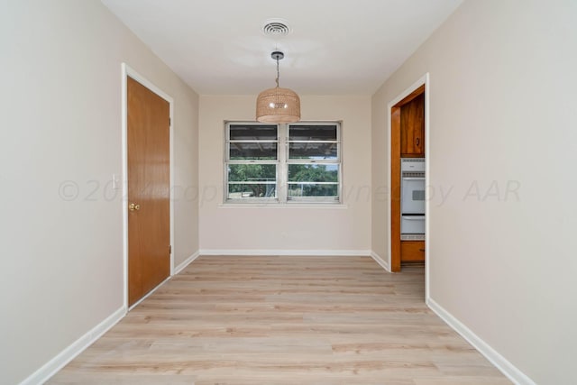 corridor with light hardwood / wood-style floors