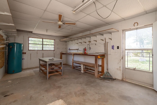 basement featuring a workshop area, ceiling fan, and a paneled ceiling