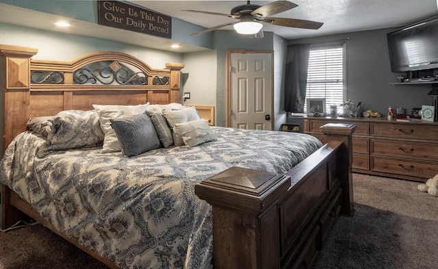 carpeted bedroom featuring ceiling fan and a textured ceiling