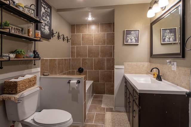 bathroom featuring tile patterned floors, vanity, toilet, and tile walls