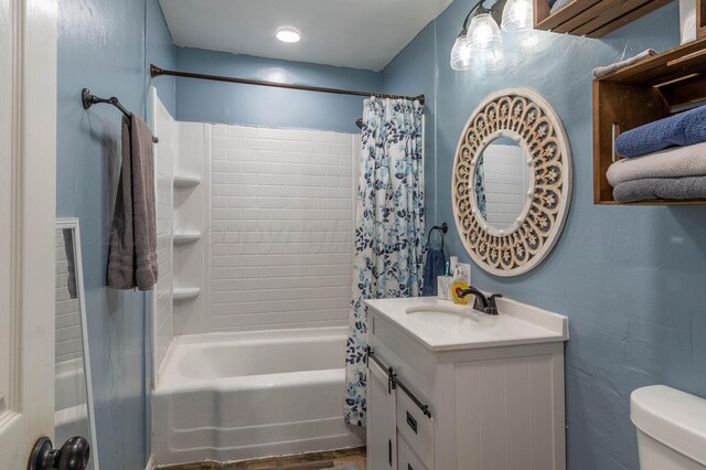 full bathroom featuring hardwood / wood-style floors, vanity, toilet, and shower / tub combo with curtain