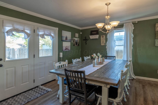 dining space with plenty of natural light, dark hardwood / wood-style flooring, crown molding, and a chandelier