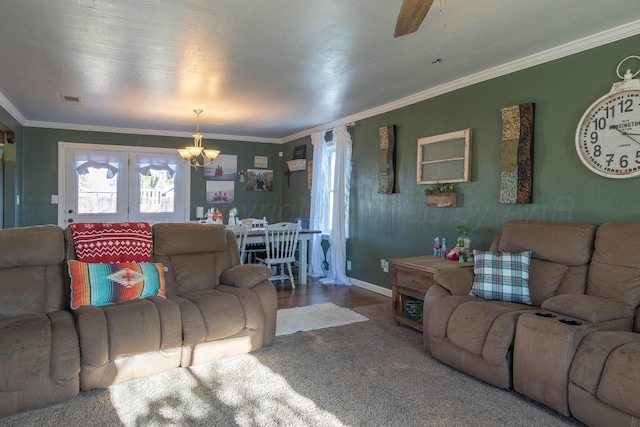 living room featuring wood-type flooring, ceiling fan with notable chandelier, and crown molding