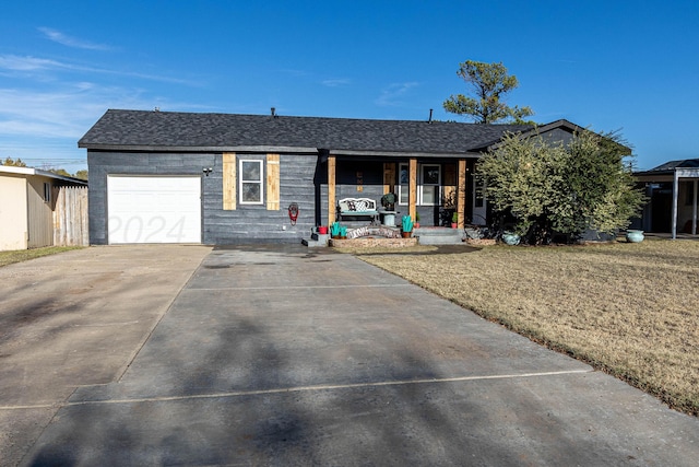 ranch-style home featuring covered porch, a garage, and a front yard