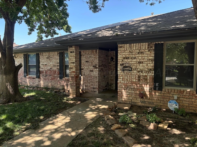 7810 Farrell Dr, Amarillo, TX 79121 - property entrance with brick siding and roof with shingles