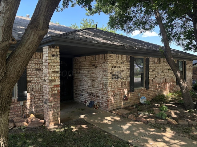 7810 Farrell Dr, Amarillo, TX 79121 - view of side of property featuring brick siding and a shingled roof
