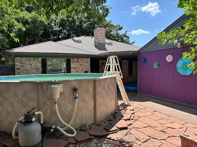 7810 Farrell Dr, Amarillo, TX 79121 - view of side of property featuring an outdoor pool, brick siding, a shingled roof, and a chimney