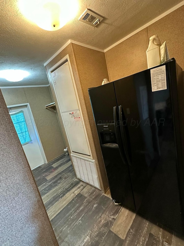 kitchen with crown molding, dark wood-style flooring, visible vents, and black refrigerator with ice dispenser