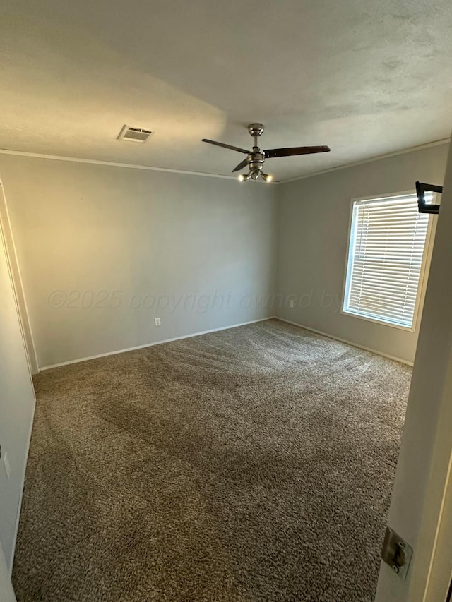 carpeted empty room featuring ceiling fan and visible vents