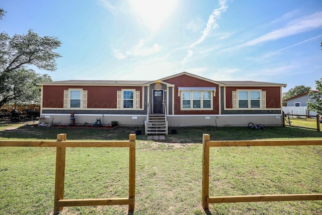 manufactured / mobile home featuring entry steps, a fenced front yard, and a front yard