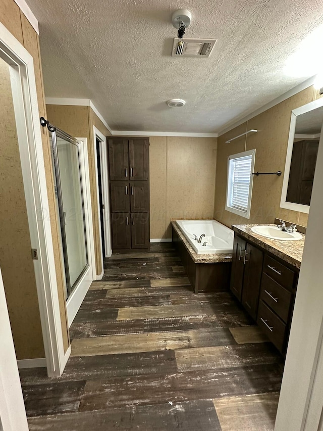 bathroom with visible vents, wood finished floors, vanity, a shower stall, and a bath