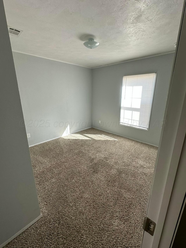 carpeted spare room featuring visible vents and a textured ceiling