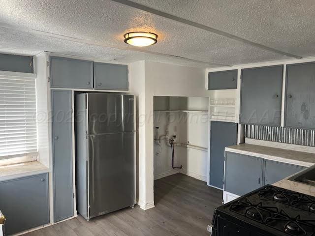 2617 W Amarillo Blvd, Amarillo, TX 79106 - kitchen featuring freestanding refrigerator, gray cabinets, dark wood-style floors, a textured ceiling, and black gas range