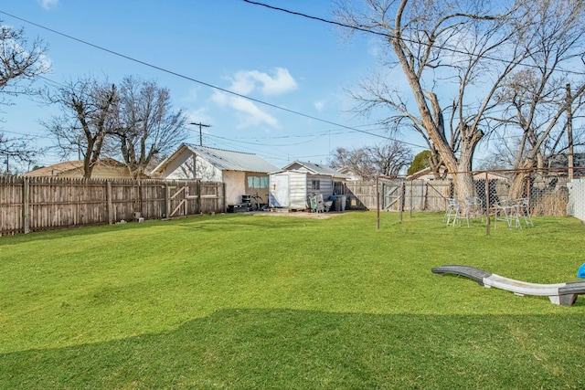 view of yard featuring a fenced backyard, a storage unit, and an outdoor structure