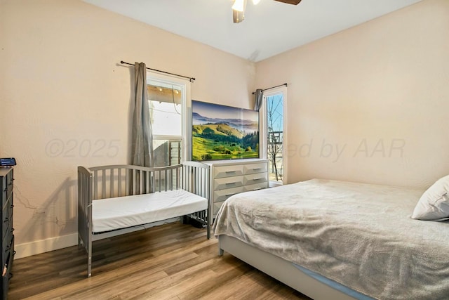 bedroom featuring wood finished floors, a ceiling fan, and baseboards