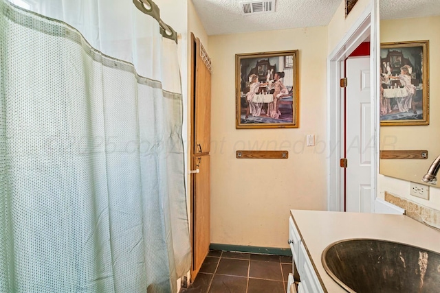 bathroom with visible vents, a textured ceiling, vanity, and tile patterned floors