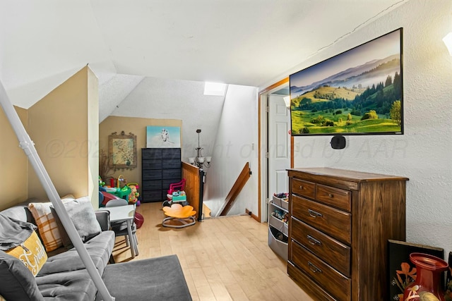 rec room featuring vaulted ceiling and light wood-style flooring